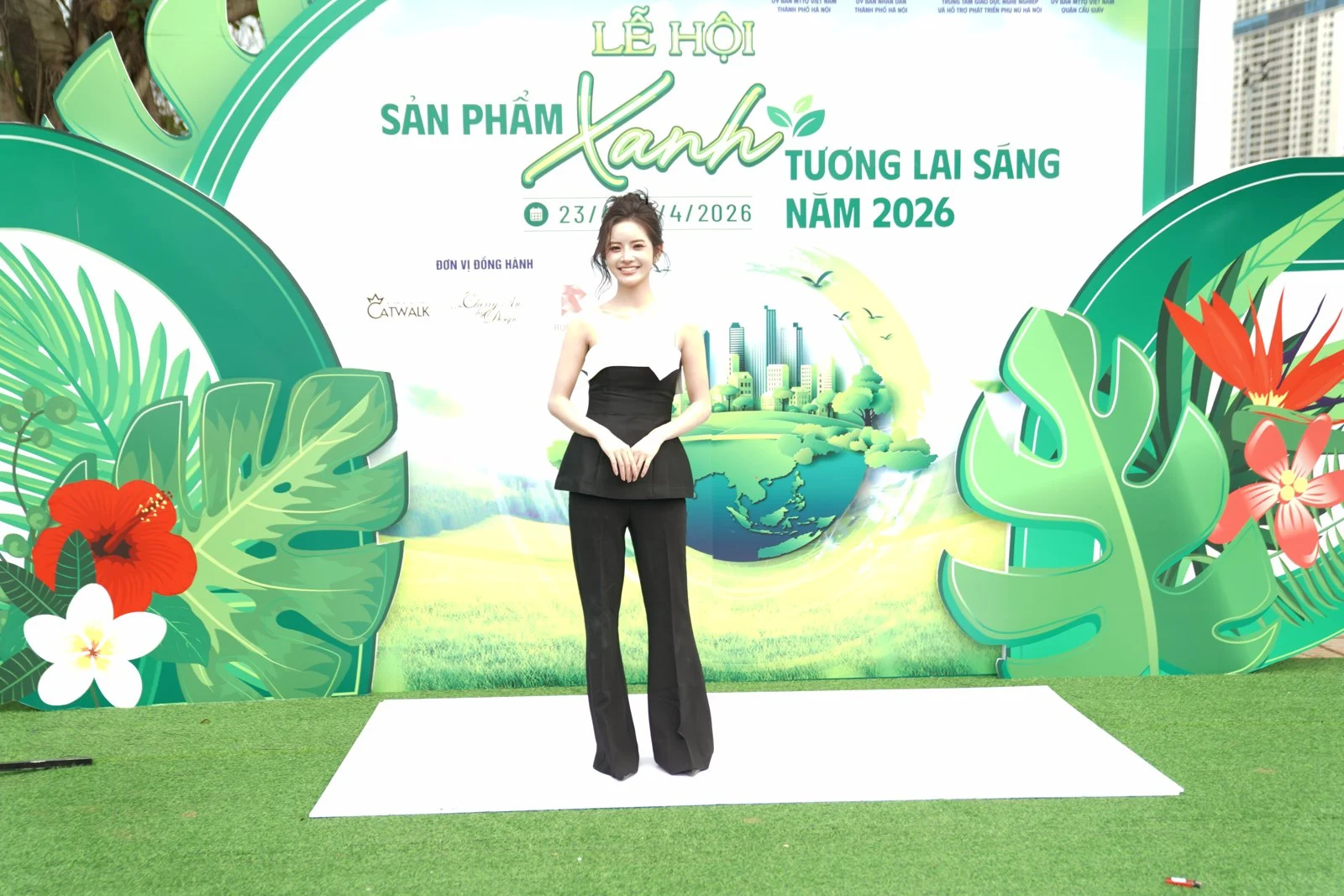 Backdrop check-in tại một lễ hội sản phẩm xanh, nền cỏ và họa tiết lá nhiệt đới